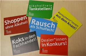 Postkarten in unterschiedlichen Farben auf Tisch liegend mit Botschaften der Suchtselbsthilfe