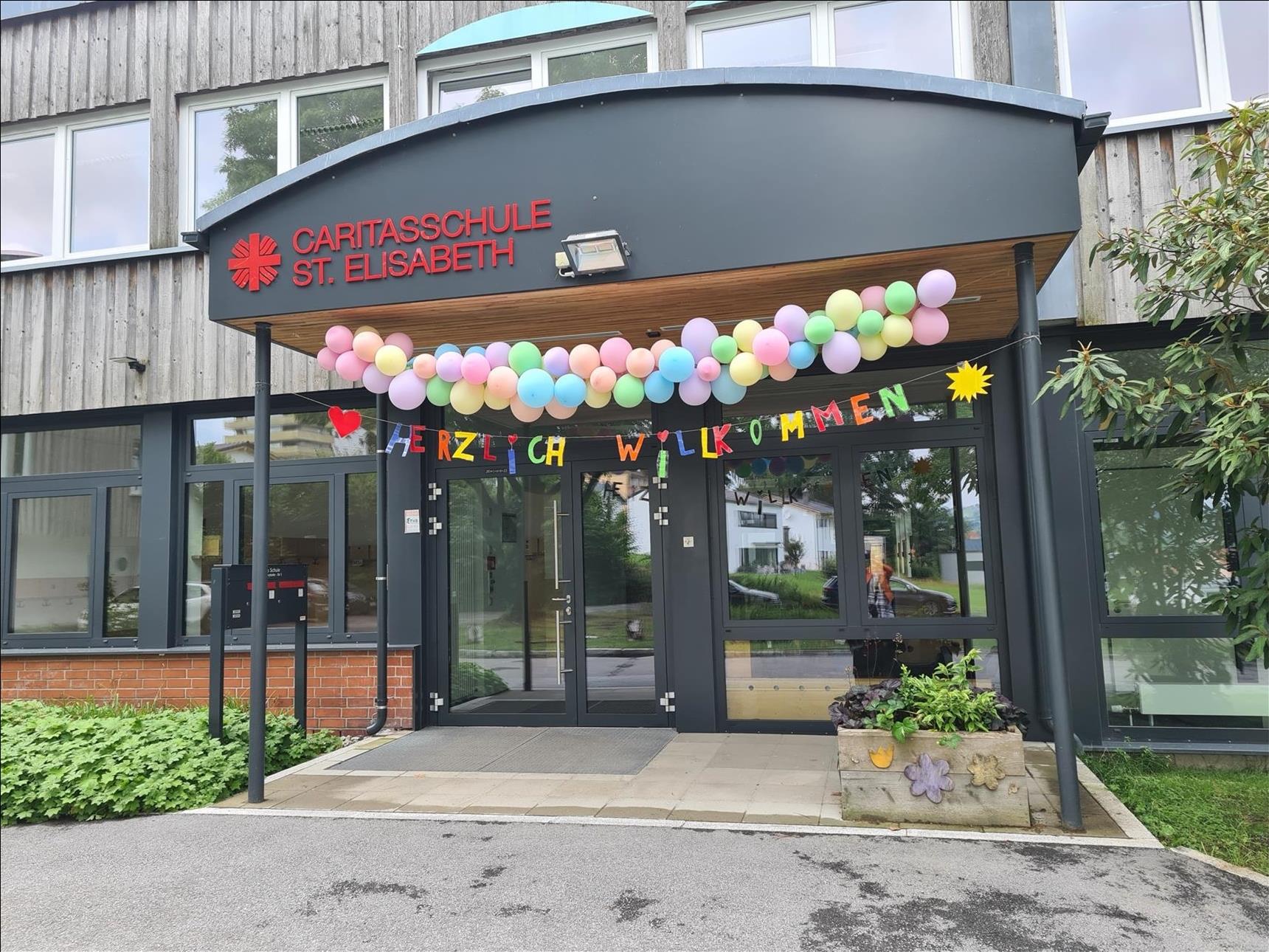 Sommerfest 2022 - Tag der offenen Schulhaustür mit Luftballongirlande und "Herzlich Willkommen". Foto: (c) Grimsmann | Caritas FRG.