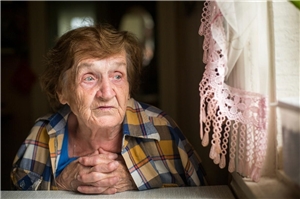 Seniorin blickt verloren aus dem Fenster. (c) fotolia.com| Marco2811