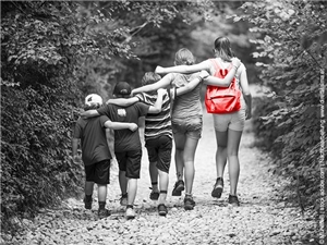 5 Kinder halten sich beim Wandern im Arm. Rückenansicht. "wie Orgelpfeiffen". Kind re. Außen trägt Rucksack. In Graustufen, roter Rucksack. © MurielleB|stock.adobe.com|bearb.Caritas FRG 