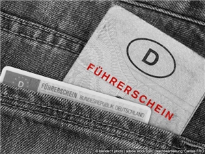 Totale: Alter und neuer Führerschein in Jeanstasche. In Graustufen, rot illustrierte Schrift. (c) blende11.photo | www.stock.adobe.com | Nachbearbeitet Caritas FRG.