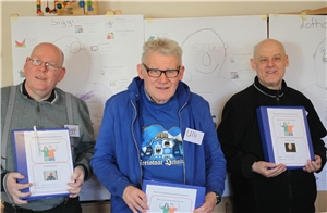 2018_02 Bildungskurs Haus St. Rafael 3 Männer stehen vor gemalten Bildern mit Körperumriss und Notizen