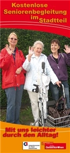 Dame mit Rollator wird von zwei Frauen auf einem Spaziergang begleitet