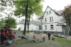 Kinderhaus außen Rutsche Außengelände des KinderHauses mit rutschenden Kindern im Bild