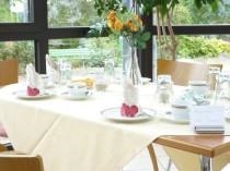 Das Bild zeigt einen gedeckten Tisch mit einem Blumenstrau� in der Mitte.