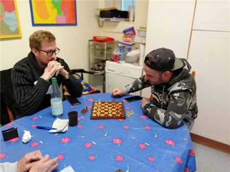 Zwei junge Männer spielen Schach. 