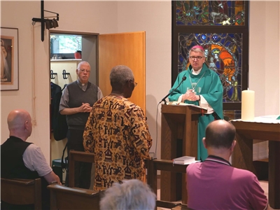 Bischof hält einen Gottesdienst mit mehreren Personen. 