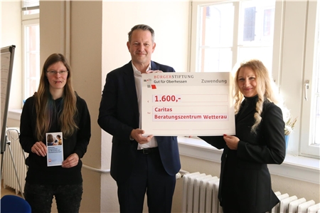 zwei Frauen und ein Mann mit einem großen symbolischen Scheck in Höhe von 1600 Euro.