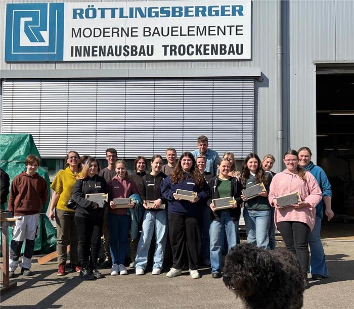 Das Gruppenbild zeigt sieben Teilnehmerinnen des Girls' Day vor dem Werkstattgebäude Röttlingsberger Innenausbau GmbH sowie deren Mitarbeiterinnen und Mitarbeiter.