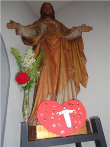 Jesusstatue mit ausgeschnittenem Papierherz der Kinder