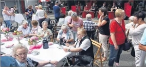 Marktplatz mit Besuchern an einem festlich gedeckten Tischen sowie eine Life-Band