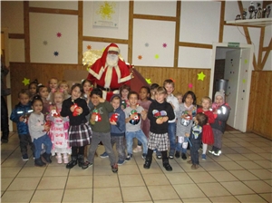 Kindergartenkinder mit gefüllten Stiefeln umringen den Nikolaus