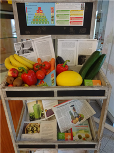 Informationsstand mit mehreren Sorten Obst und Gemüse sowie Broschüren über Ernährung