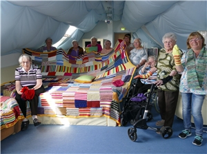 Stricken fürs Jubiläum Seniorinnen zeigen die von ihnen gestickten Decken, Schals und Socken
