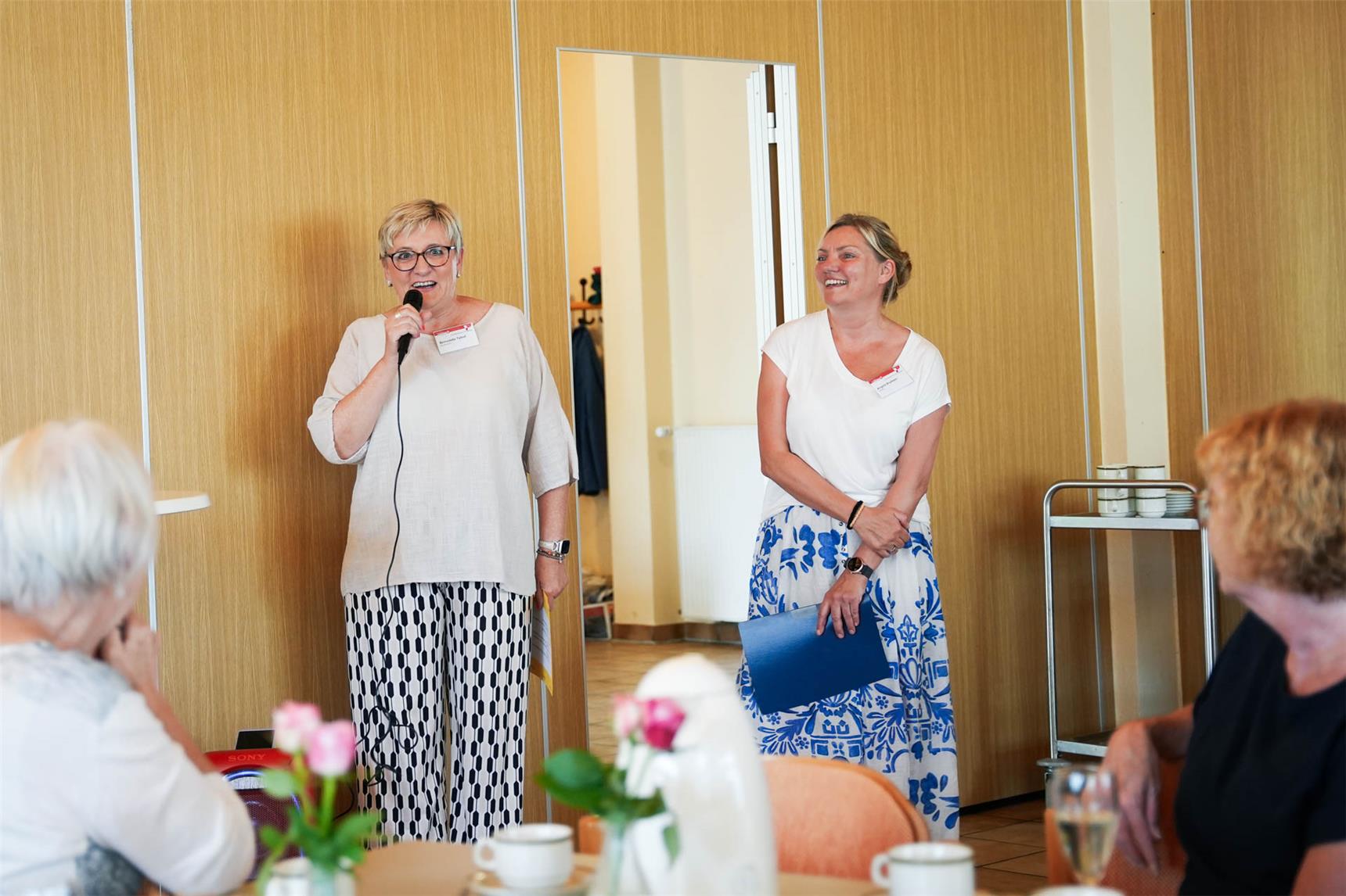 Koordinatorin Bernadette Talhof und Leiterin Angela Boyksen stehen nebeneinander und begrüßen die Gäste.