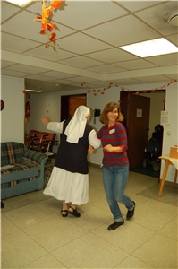 Zwei tanzende Mitarbeiter*innen der Pflegeheimat