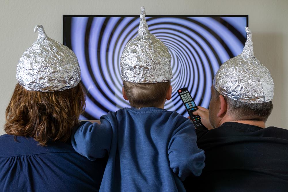 3 mit Aluhüten schauen Fernsehen