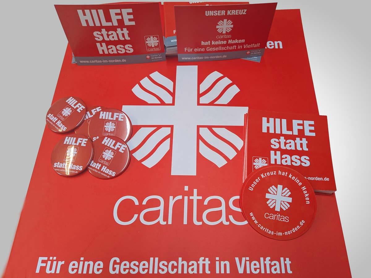 Foto von Plakat, Aufkleber, Postkarten und Buttons mit Kampagnenmotiven