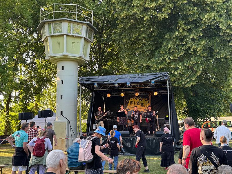 Rock-Band auf der Bühne, davor tanzen Leute
