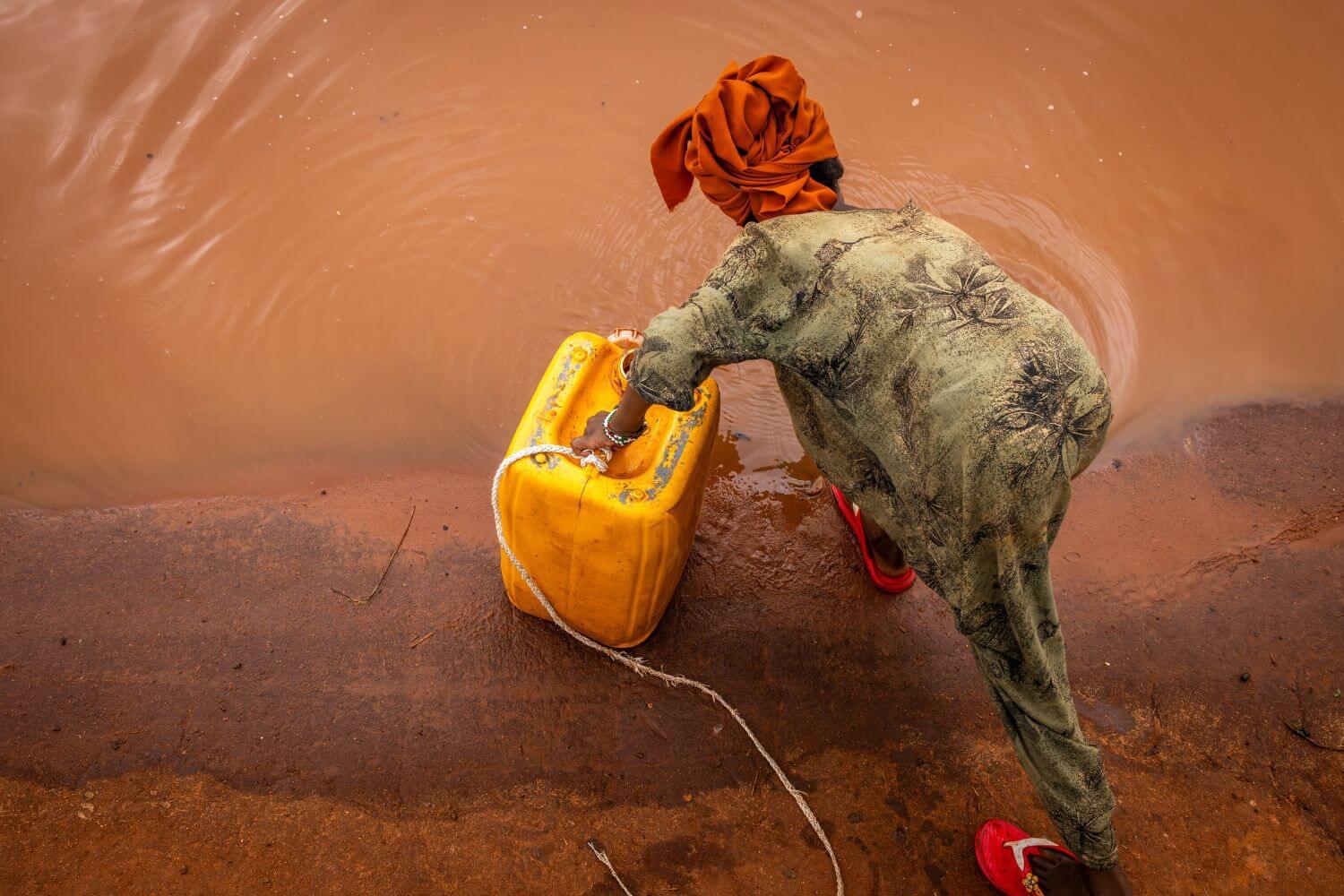 Samira holt unsicheres Trinkwasser aus einer Pfütze in Äthiopien