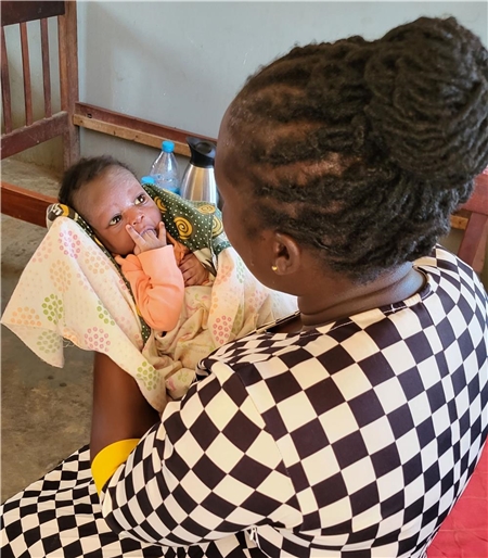 Eine der freiwilligen Helferinnen von „Mama Betty“ hält ein wenige Tage altes Baby auf dem Arm, welches kürzlich gefunden wurde und in das Waisenhaus von Mama Betty gekommen ist.