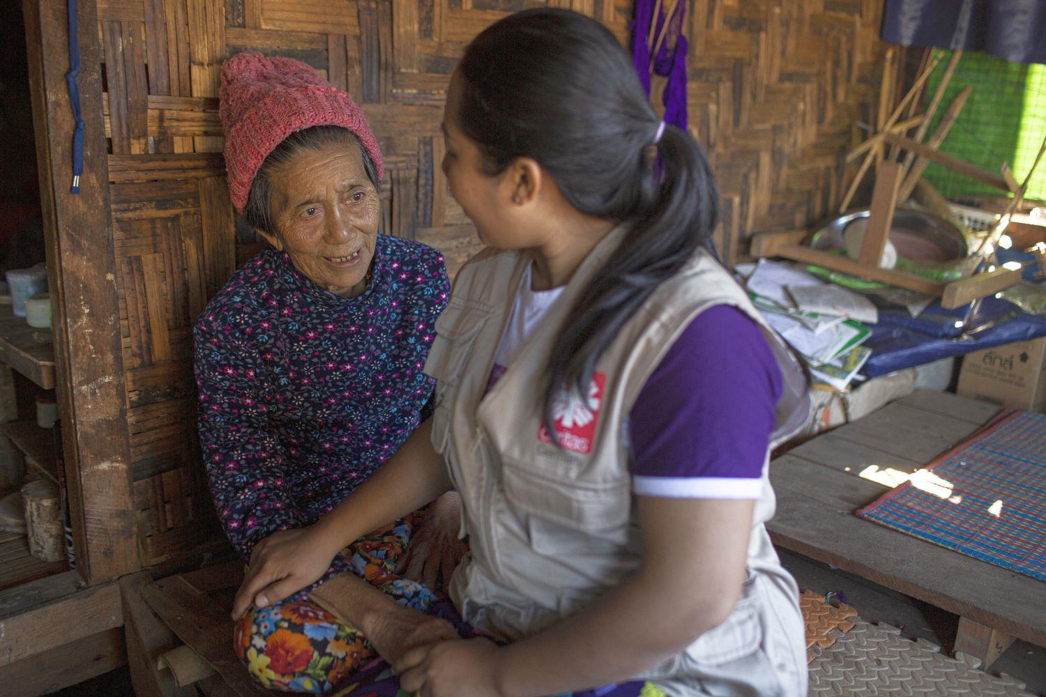 Caritas Mitarbeiterin im Gespräch mit einer Begünstigten in Myanmar