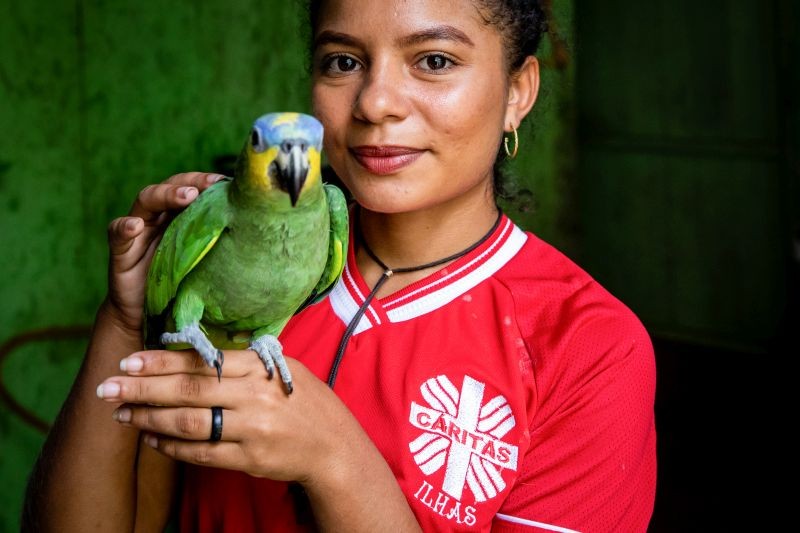 Eine Mitarbeiterin mit einem Papagei auf der Hand