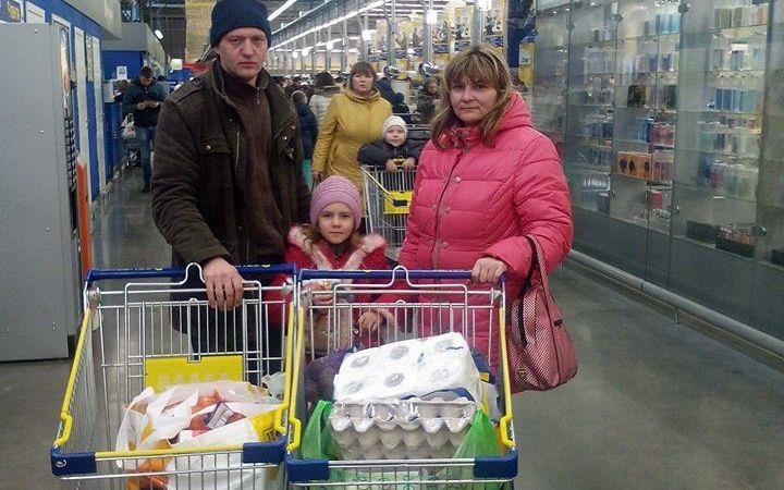 Familie aus der Ukraine mit vollen Einkaufswagen