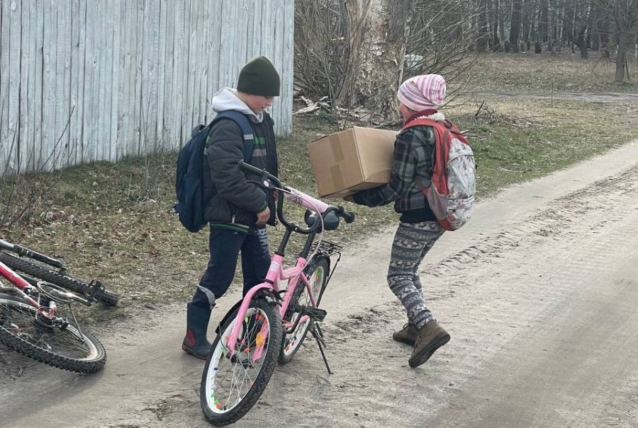 Kinder in der Ukraine nehmen die Caritas-Pakete entgegen.
