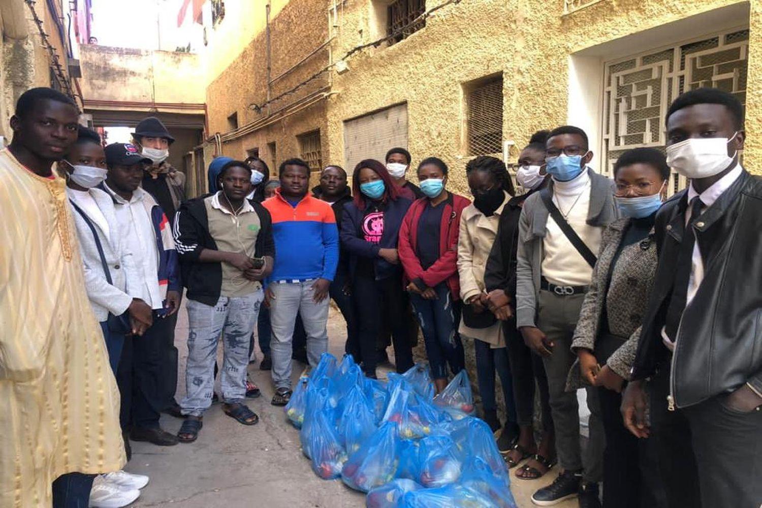 Eine Gruppe von Migranten erhält Lebensmittelpakete.