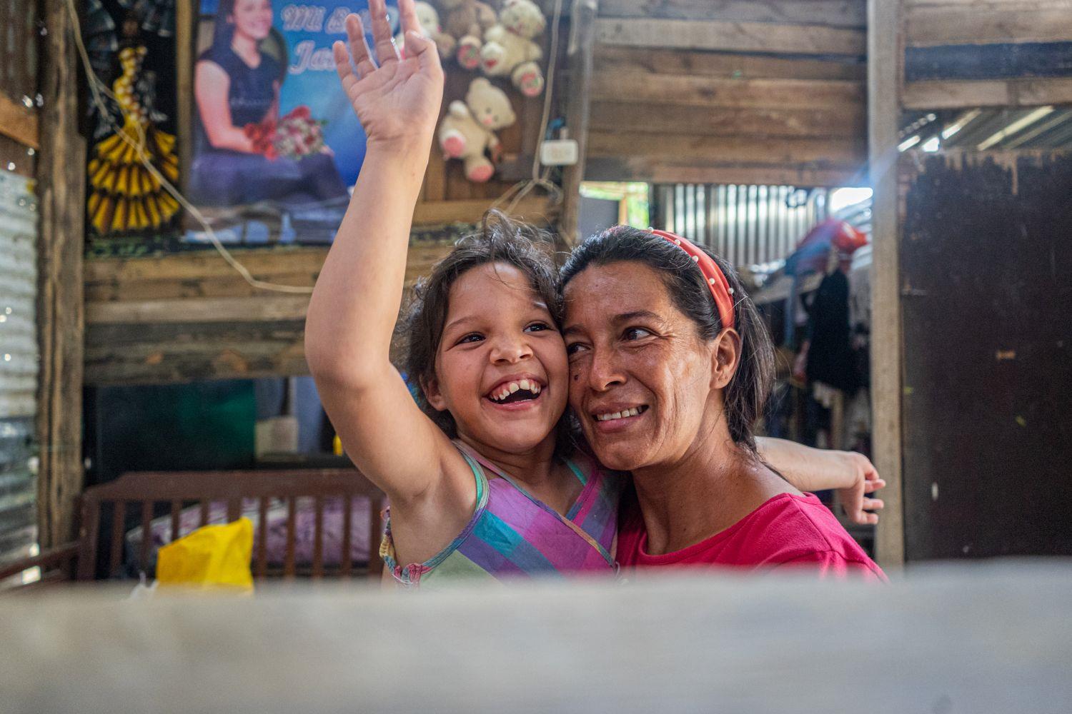 Frau mit kleinem Mädchen auf dem Arm in Kolumbien, beide strahlen