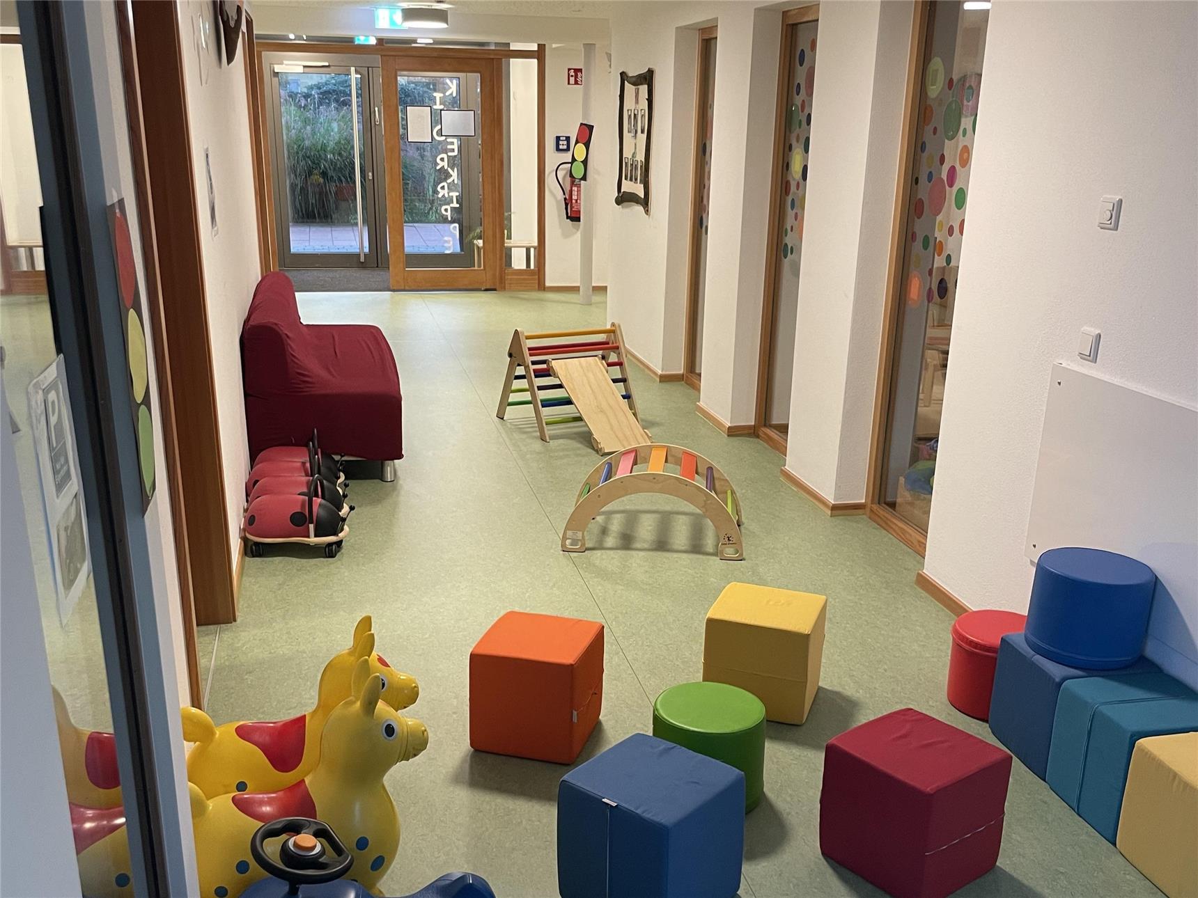 Ein Flur, der mit verschiedenen Spielzeugen und einem Stuhl ausgestattet ist, ideal für Kinder und deren Aktivitäten.
