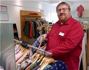 CarMen-Mitarbeiter Niklas Franzen im Kleiderladen