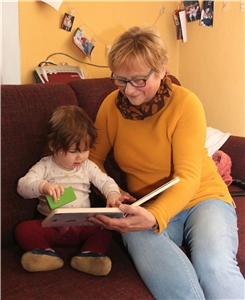 Familienpflegerin liest aus einem Buch vor