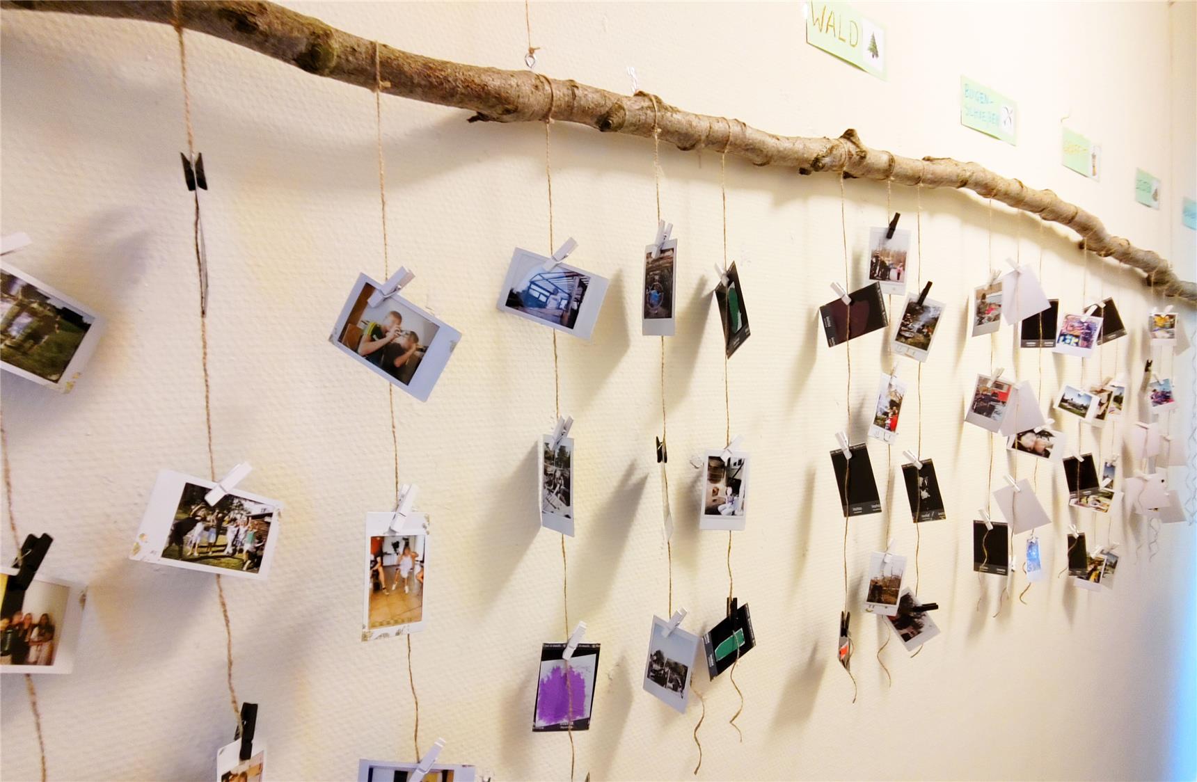Eine Fotowand mit vielen Polaroids von Kindern und Jugendlichen in verschiedensten Situationen