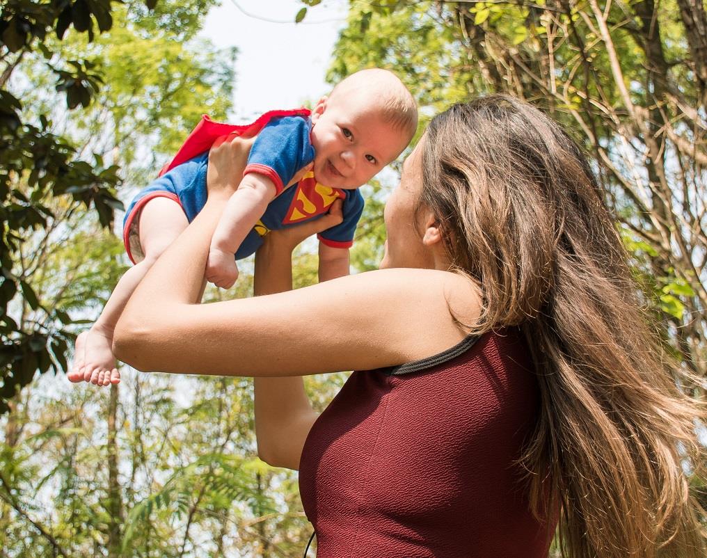 Mutter mit Baby im Superheldenkostüm