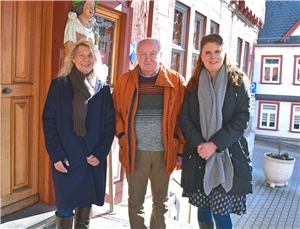 Gruppenbild mit einem Mann und zwei Frauen am Rathaus.