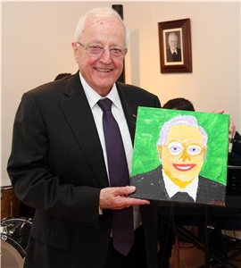 Horst Schroff hält ein gemaltes Porträt von sich in die Kamera