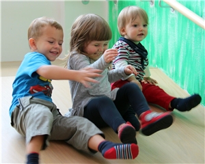 Kinderkrippe2 Kinder rutschen eine Rampe in der Krippe hinunter.
