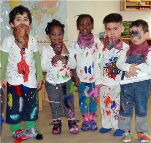 Kindergartenkinder in farbbekleckster Kleidung