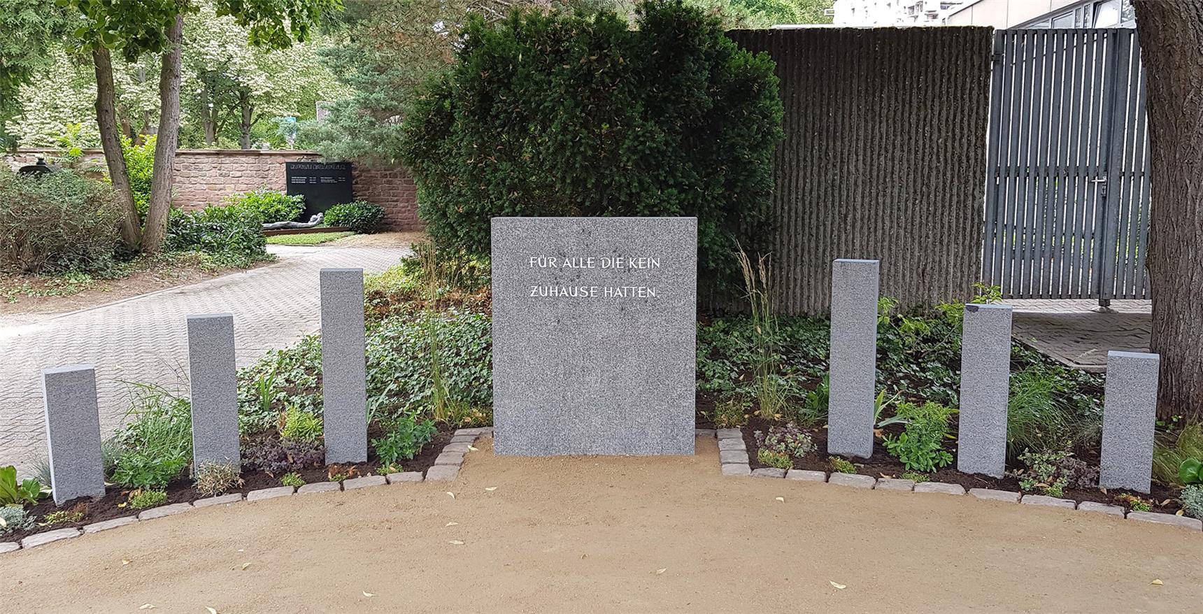 Die Gedenkstätte im Ganzen: In der Mitte der Gedenkstein mit der Aufschrift „Für alle, die kein Zuhause hatten“. Rechts und links davon sind kleinere steinerne Stelen.