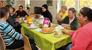 Mehrere Frauen sitzen an einem Tisch und essen Kuchen