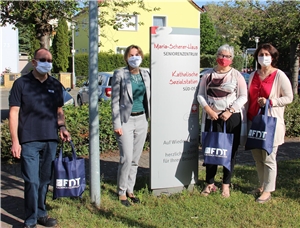 Betriebsrat Reiner Kern (v.l.) und Geschäftsführerin Alexandra Strassl von FDT übergeben die Masken an Caritas-Vorstandsvorsitzende Regina Hertlein und Heimleiterin Snezana Manojlovic. 