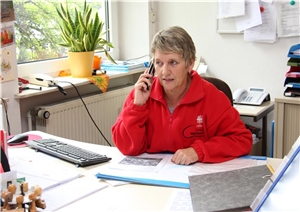 Seniorenberaterin Elfriede Lehmann sitzt am Schreibtisch und telefoniert