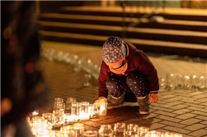 Ein Kind zündet bei der Aktion 1 Million Sterne eine Kerze an
