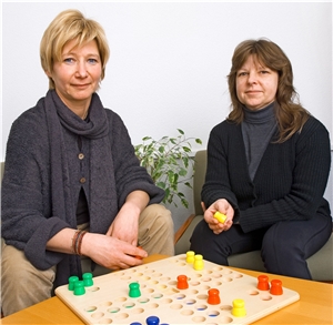 Tagesstätte Eine Mitarbeiterin spielt mit einer psychisch erkrankten Dame Mensch ärgere dich nicht.