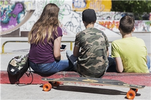Drei Jugendliche mit Skateboard