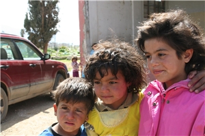 Das Foto zeigt drei syrische Flüchtlingskinder vor einer aufgegebenen Schule im Bekaatal im Libanon.