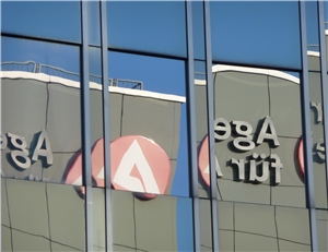 Das Logo der Arbeitsagentur spiegelt sich in der Hausfassade.