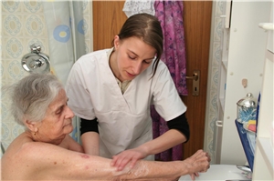 Eine Pflegerin hilft bei der Körperhygiene